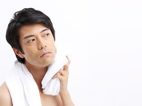 タオルで顔を拭いている男性